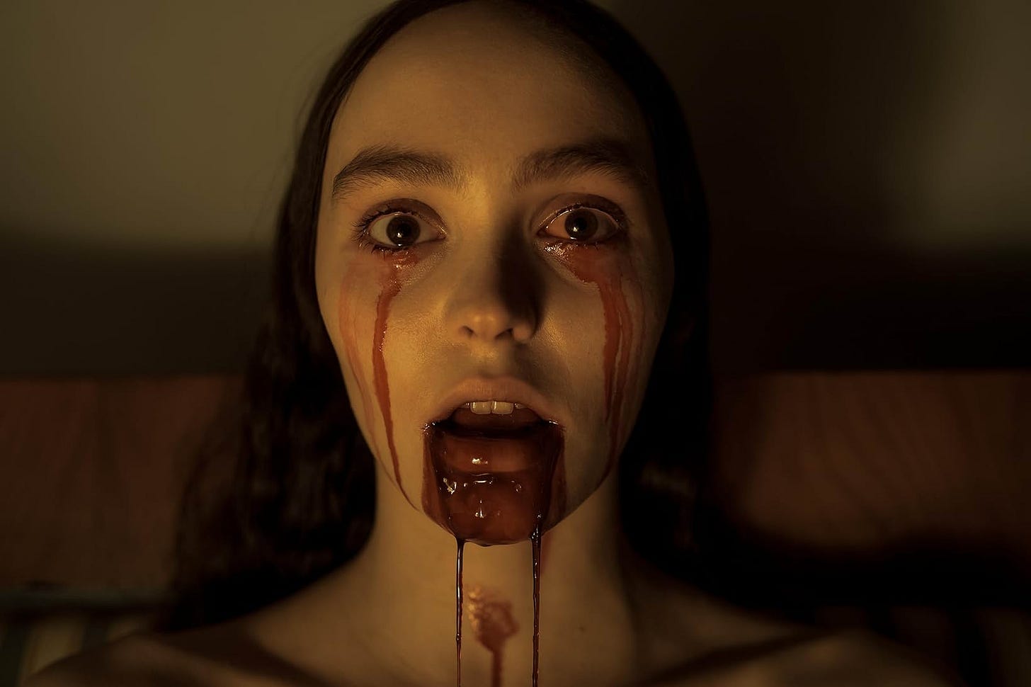 A still from the film. Lily-Rose Depp stares wide-eyed, blood dripping from her eyes and mouth.