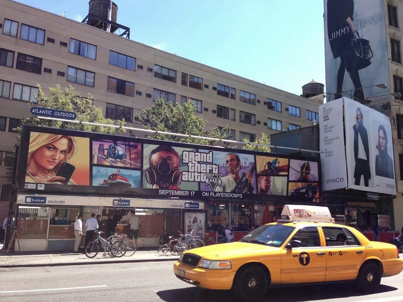 An advertisement for GTAV spans the length of a building just above Houston St . in NYC. An advertisement for GTAV spans the length of a building just above Houston St . in NYC.