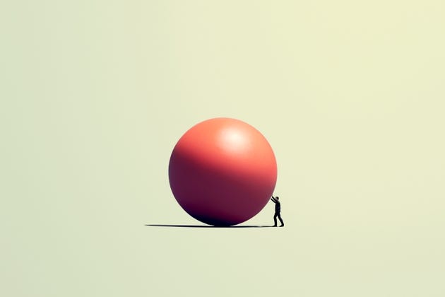 Man pushes a huge orb
