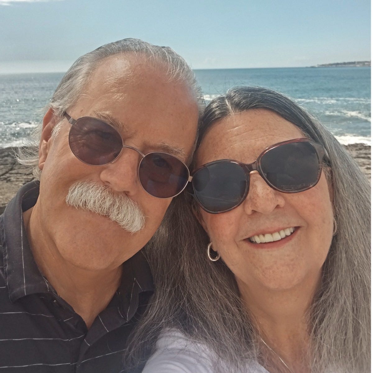 Couple smiling in front of the ocean