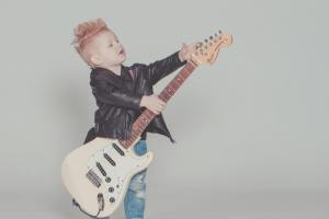 boy wearing black jacket holding electric guitar