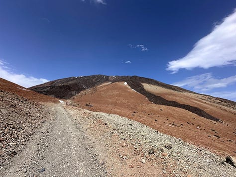 The vast orange desert-like landscape of Montana Blanca in Tenerife, raw and untouched volcanic terrain under bright sunlight.