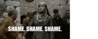 a woman in a hijab is standing in front of a group of people with the words shame shame shame written below her