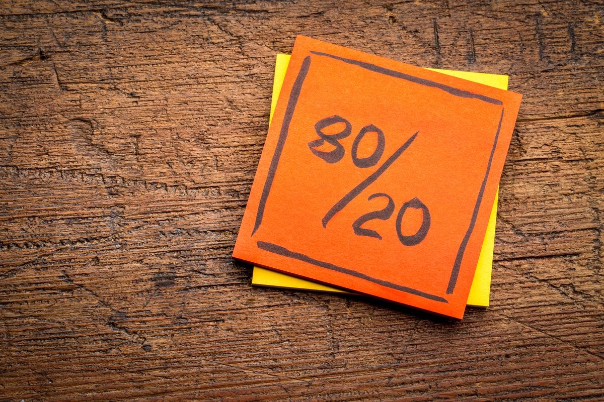 "80/20" on orange note on wooden background.