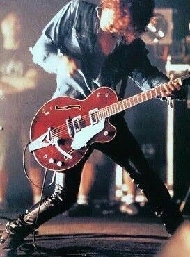 This may contain: a man playing an electric guitar on stage This may contain: a man playing an electric guitar on stage