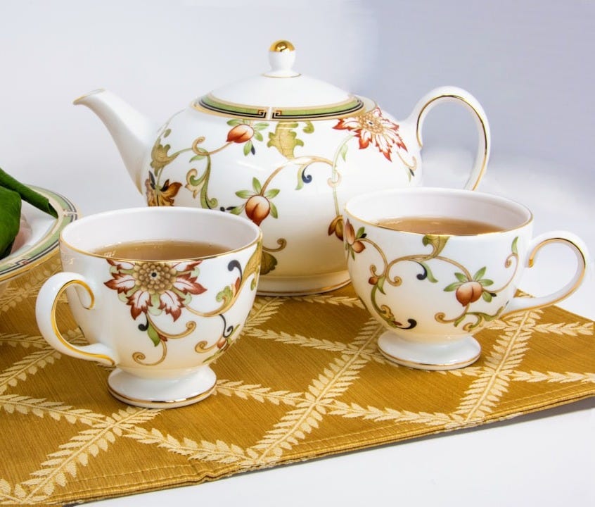 white-and-multicolored mugs filled with tea beside fruits