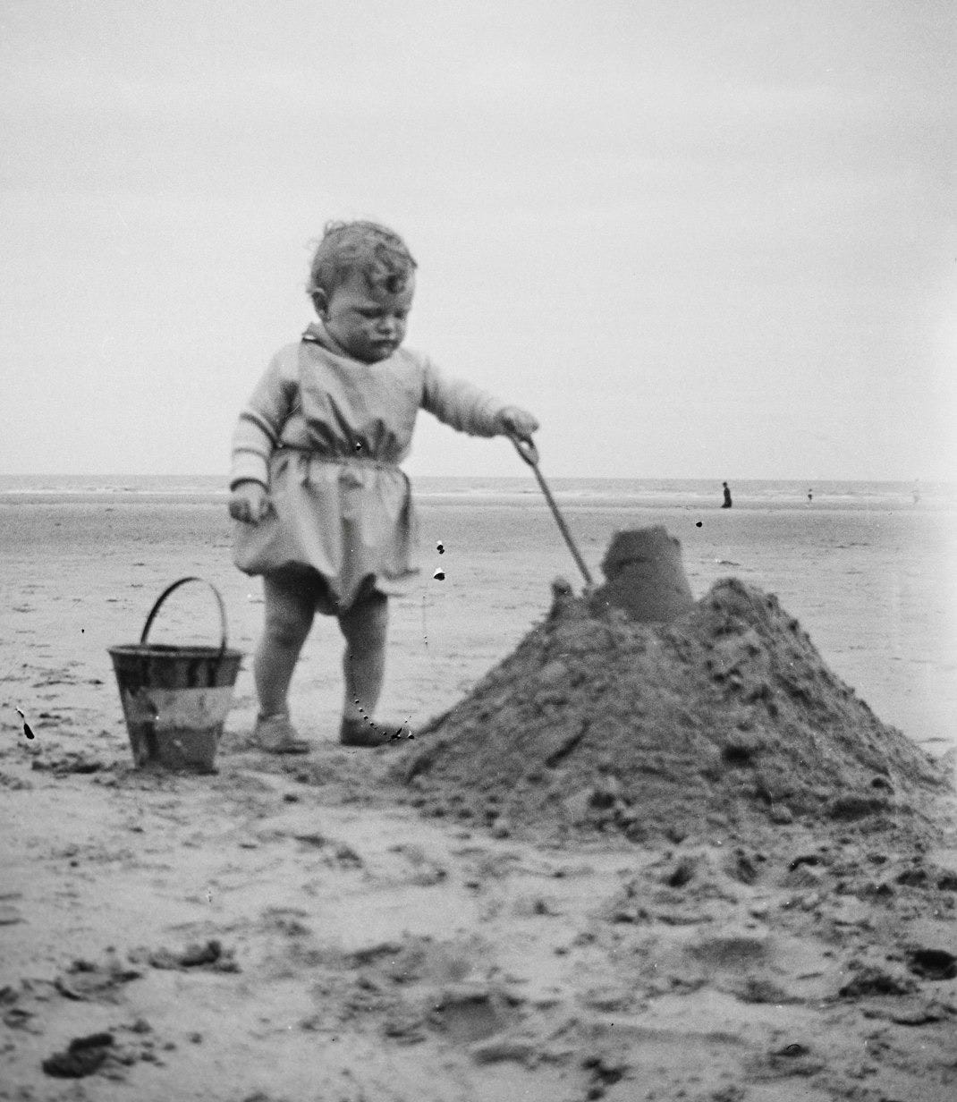 a little girl that is standing in the sand
