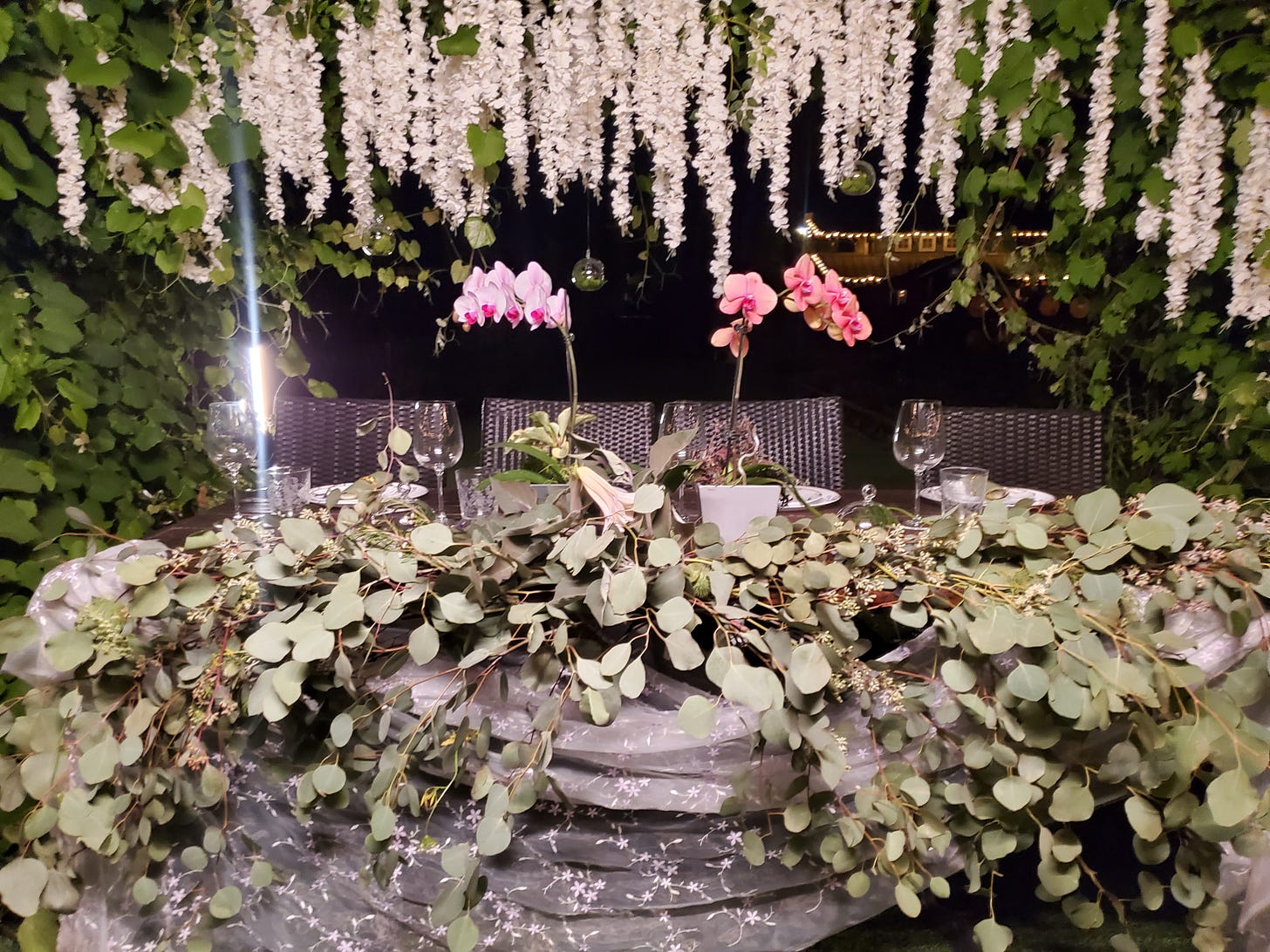 The head table of a wedding set with orchids, datura, and wisteria for the movie The Not by Courtney Hoskins.