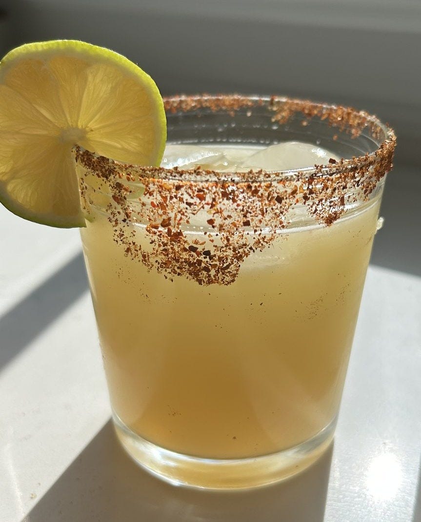 Clean margarita over ice with a chili-lime Tajín rim and a lime wheel Clean margarita over ice with a chili-lime Tajín rim and a lime wheel