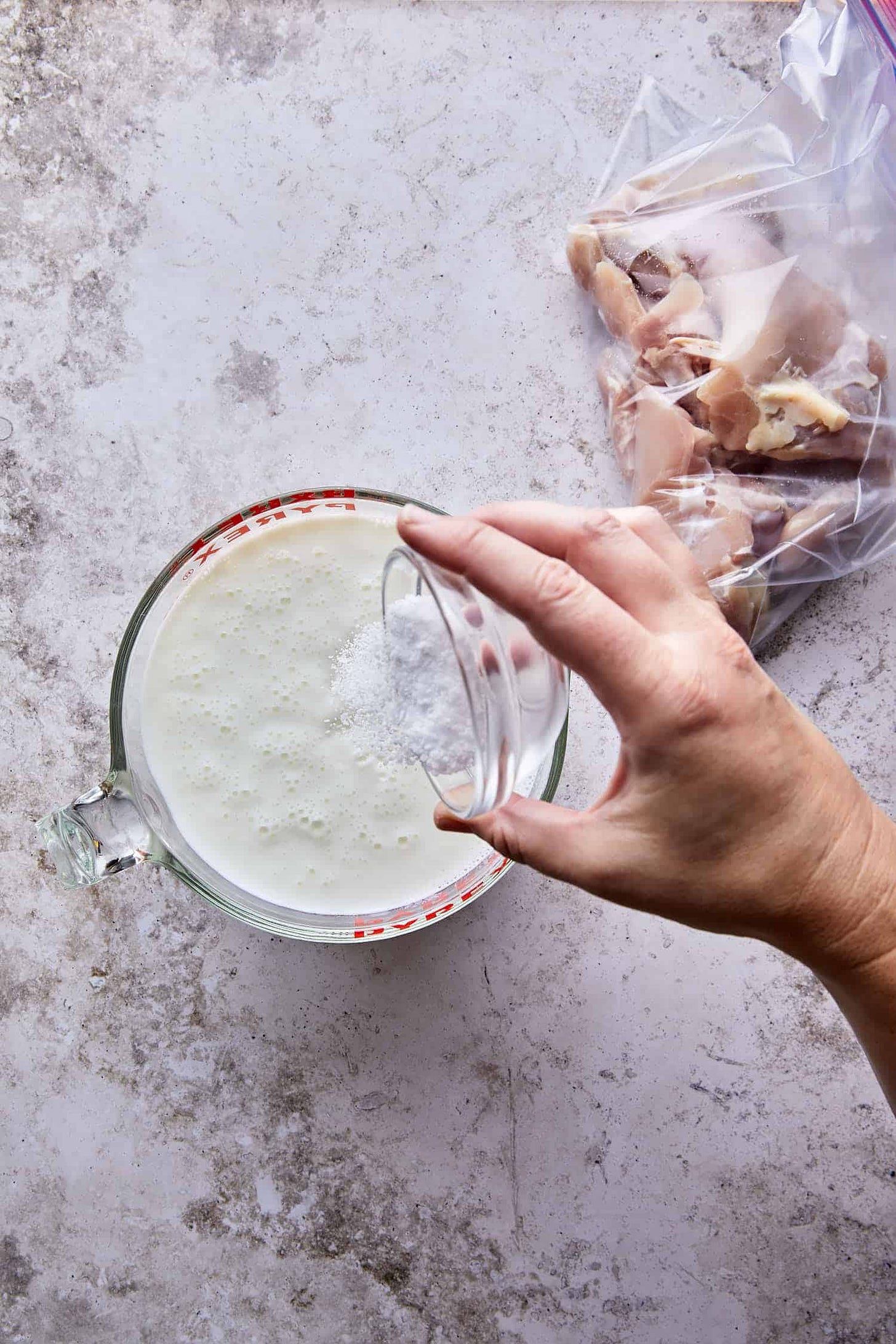 Bowl of buttermilk and kosher salt brine, prepping juicy chicken for the best fried chicken sandwich recipe.
Bowl of buttermilk and kosher salt brine, prepping juicy chicken for the best fried chicken sandwich recipe.