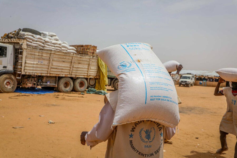Workers transport bags of WFP food on their backs across a sandy landscape in Adre, Chad, backdropped by a WFP food truck. Photo: WFP/Arete/Salamon Djek Workers transport bags of WFP food on their backs across a sandy landscape in Adre, Chad, backdropped by a WFP food truck. Photo: WFP/Arete/Salamon Djek