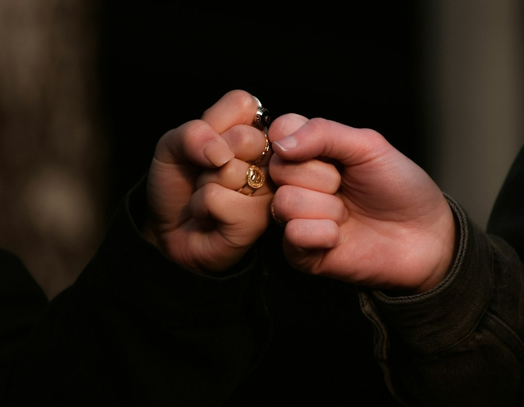 person holding gold ring in dark room