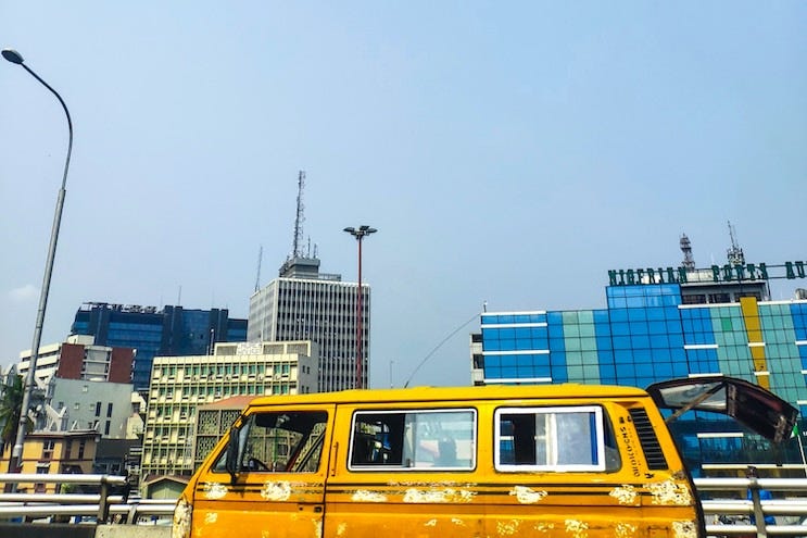 A moving danfo against a Lagos skyline. Credit: Babatunde Olajide / Unsplash A moving danfo against a Lagos skyline. Credit: Babatunde Olajide / Unsplash