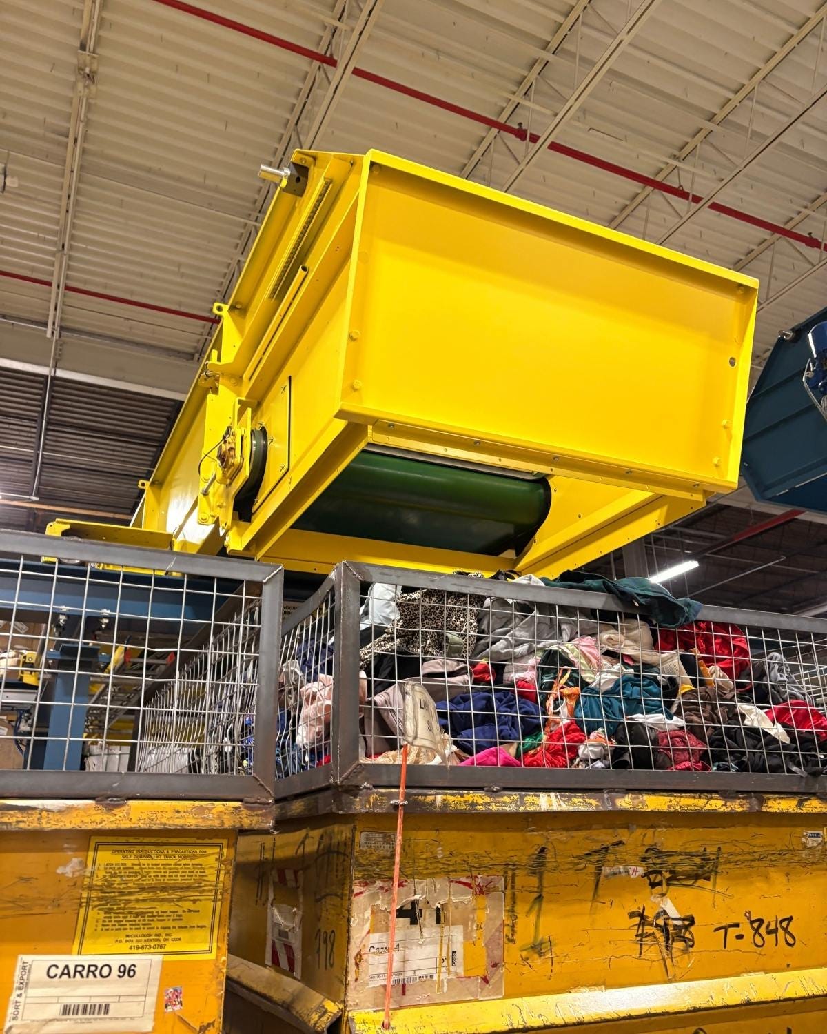 yellow machine dumping clothes into bins