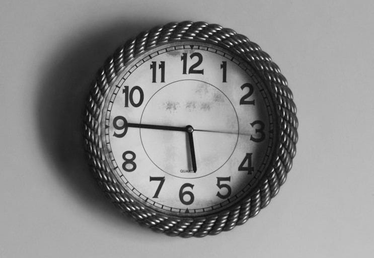 black and white analog wall clock at 10 10