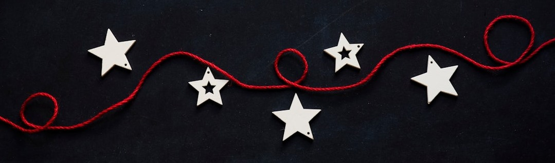 white stars cutout on black surface with red string