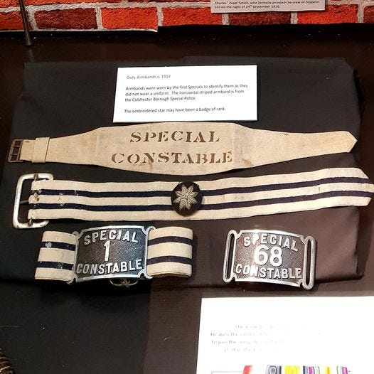 Three Special Constable armbands. The first is cream with stencil letters spelling SPECIAL CONSTABLE, the 2nd horizontal black and white stripe pattern with an embroidered star patch in the centre and the third a black and white horizontal stripe pattern with a central metal buckle reading Special Constable 1.