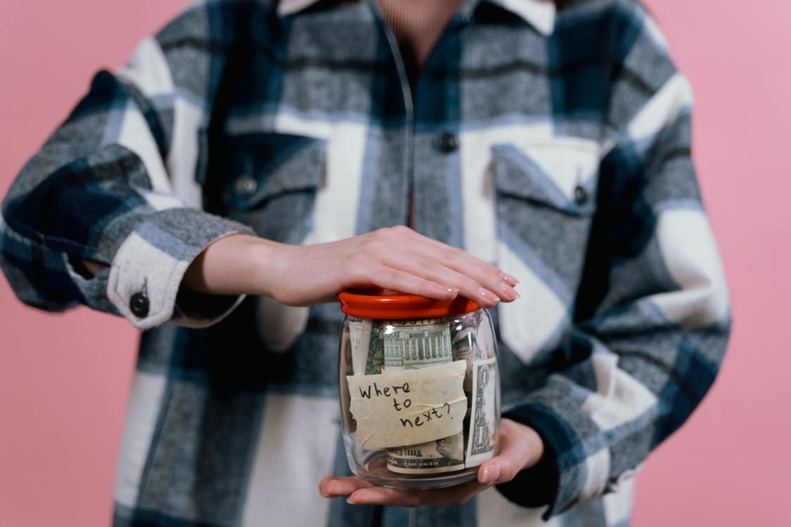 Woman Holding A Glass Jar With Paper Bills