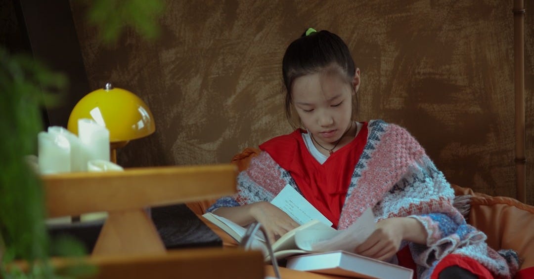 Young girl reading a book indoors