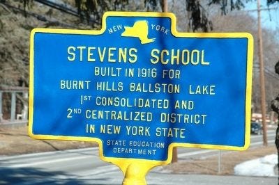 New York state historical marker reading "Built in 1916 For Burnt Hills Ballston Lake 1st Consolidated And 2nd Centralized District In New York State"