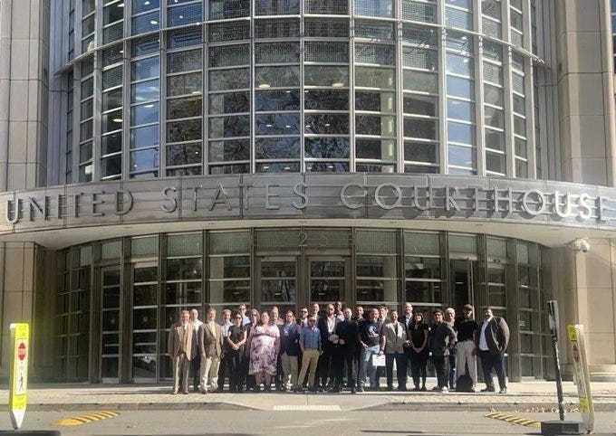 A large group of supporters gathered on the steps of a United States Courthouse, likely attending proceedings related to Richard Heart's SEC fraud case A large group of supporters gathered on the steps of a United States Courthouse, likely attending proceedings related to Richard Heart's SEC fraud case