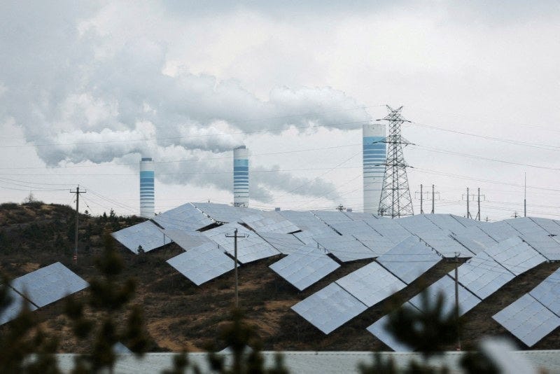Smoke rises from chimneys near solar panels in Shaanxi Smoke rises from chimneys near solar panels in Shaanxi