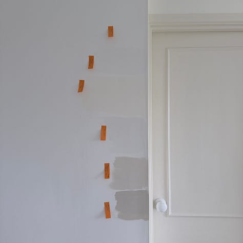 Photographs of a white door and wall with paint samples of different white paints with orange post it notes labelling the paint colours