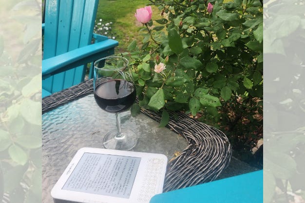 Kindle, red wine in wine glass, rose bush, blue chairs