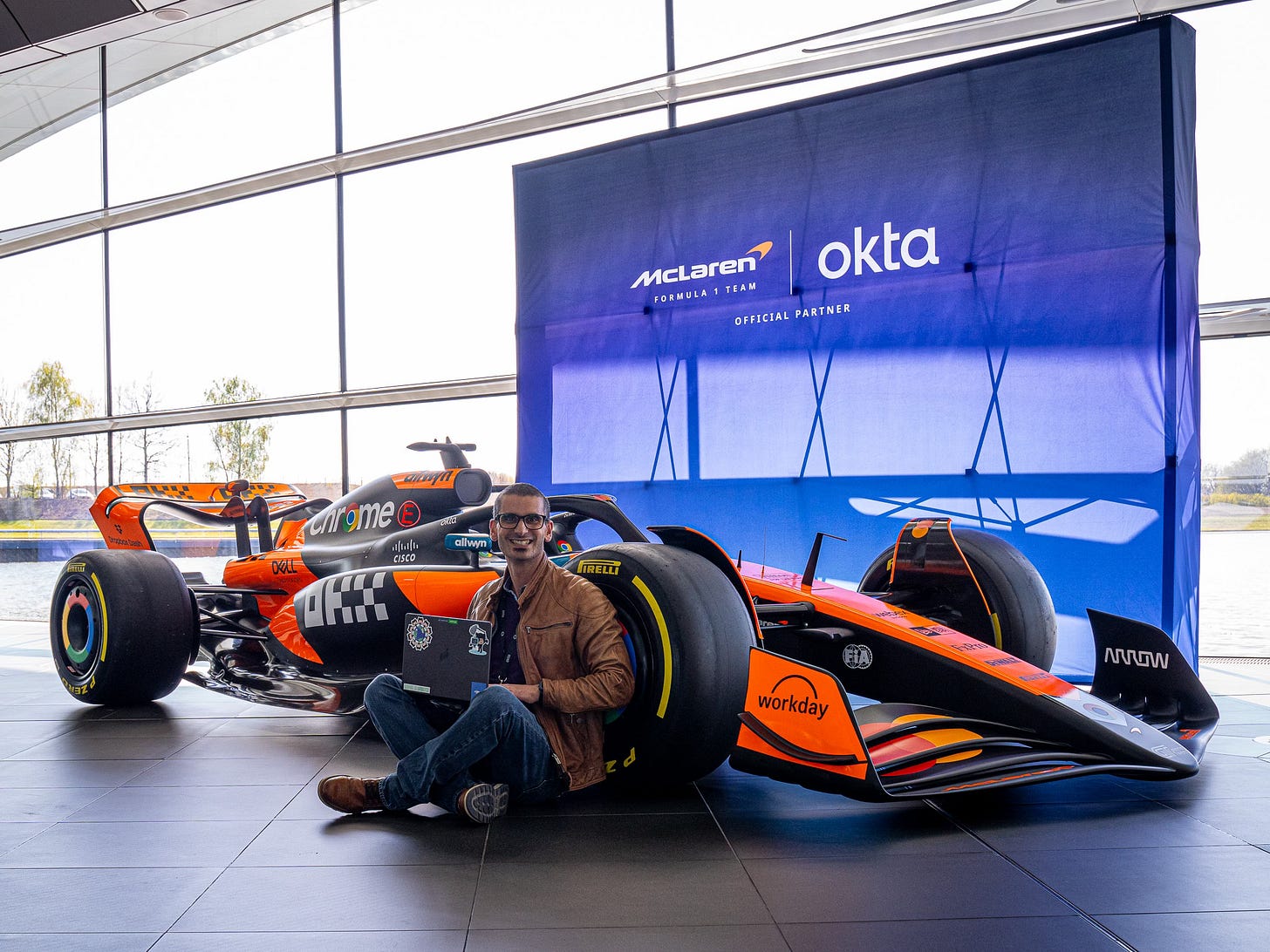 Eddie sitting with his laptop next to a formula one car