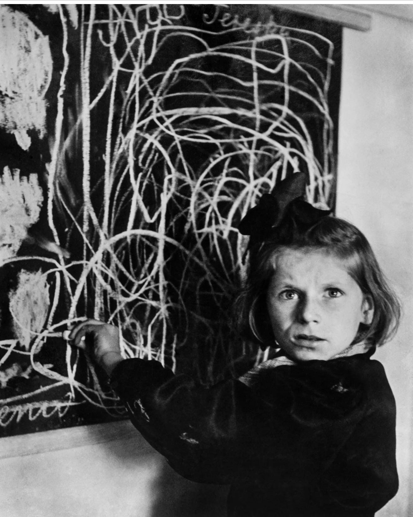 A poignant post-war image: the previously unidentified Teresa Adwentowska, a child severely affected by wartime trauma, drawing 'home' on a blackboard in a Warsaw residence for disturbed children, 1948.
