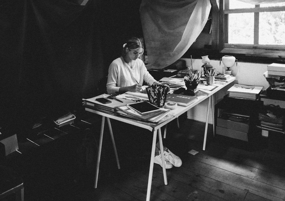 grayscale photo of man sitting on chair