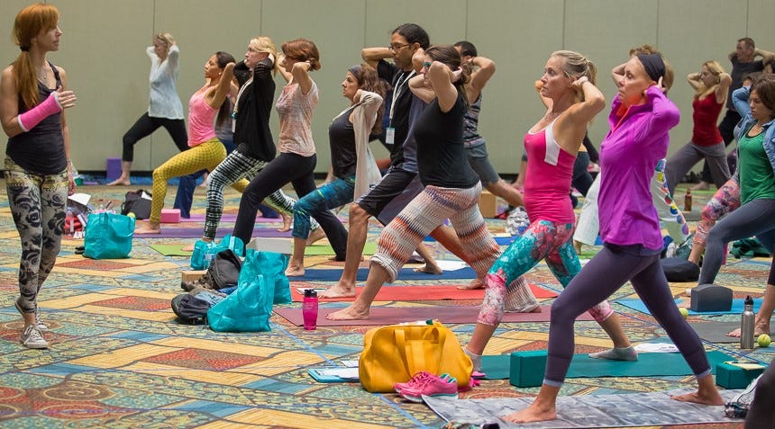 Image of Bo teaching at a conference, with her hair in a ponytail and a fuchsia pink cast on her right arm