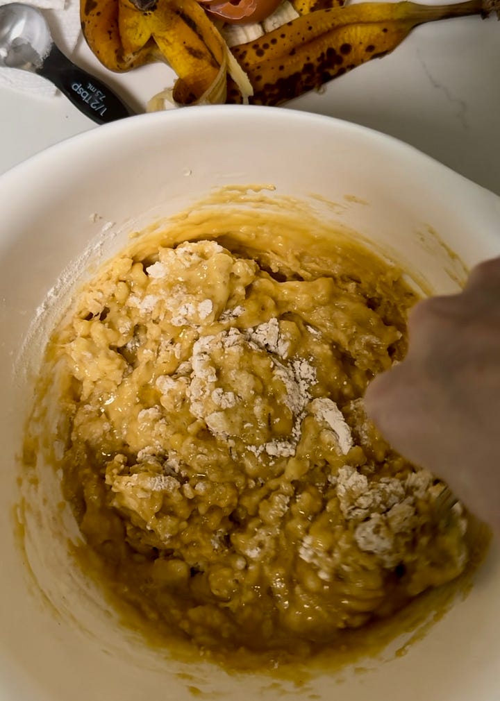 Left: White bowl with a hand mixing yellow batter. Right: A loaf of blueberry banana bread next to a knife.