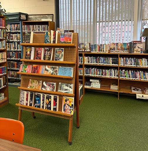 Books and magazines on shelves and display racks at small town library Books and magazines on shelves and display racks at small town library
