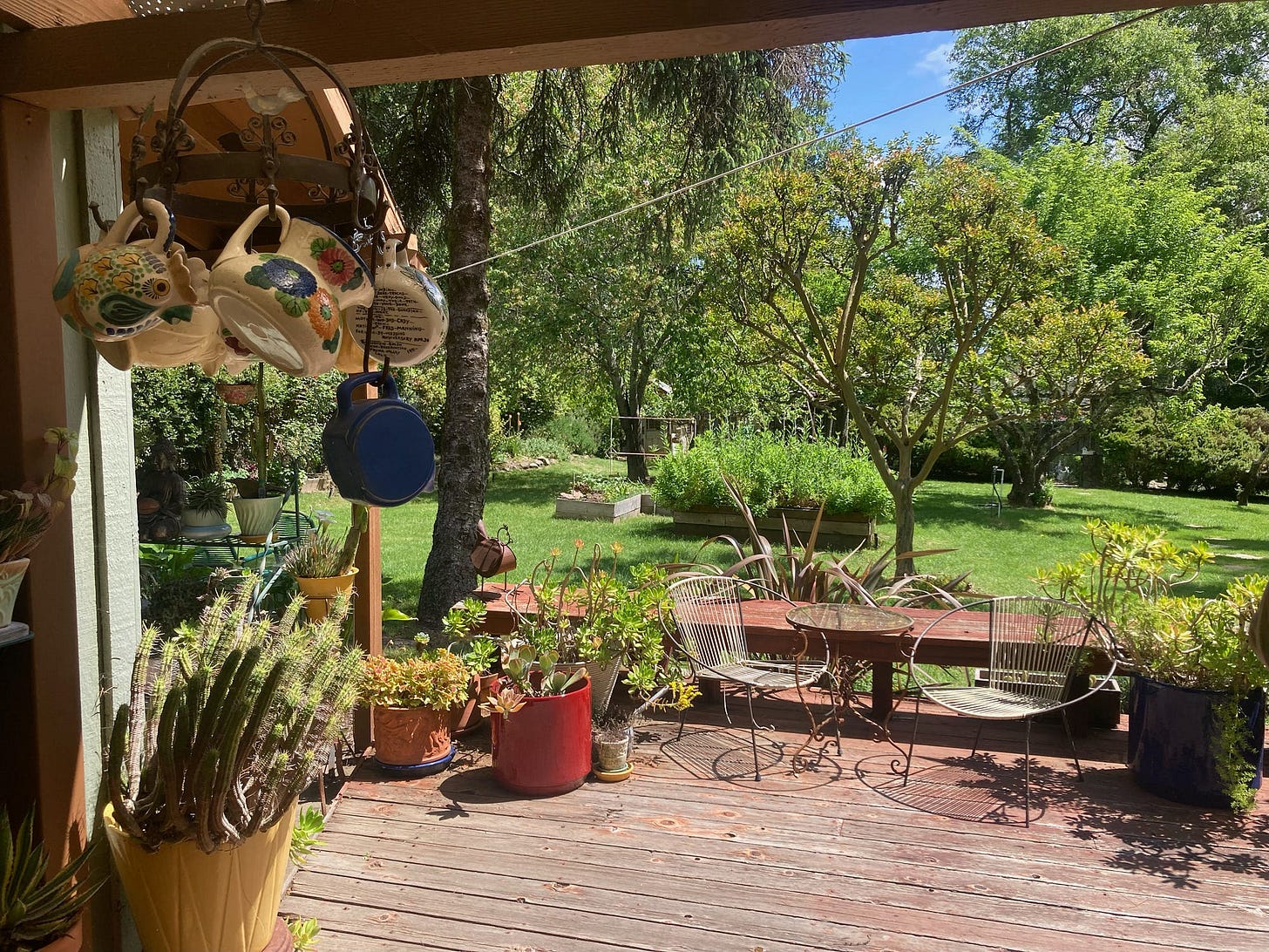 A gorgeous and welcoming green-grass backyard with a wood deck and table and chairs