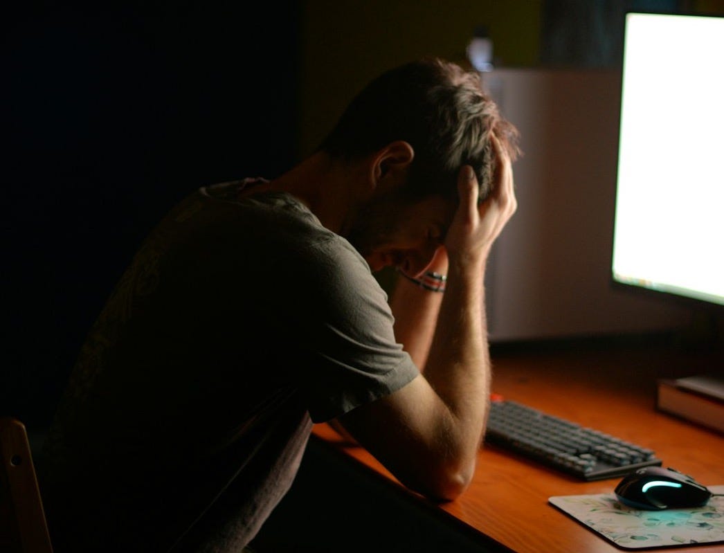 a man sitting at a desk in front of a computer