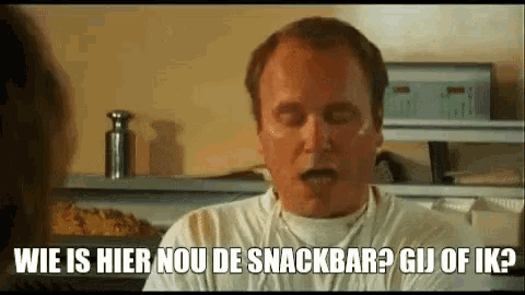 a man in a white shirt is making a funny face while talking to someone .