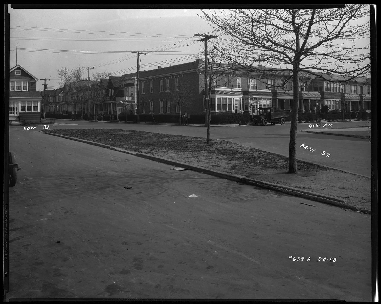 Image shows a photograph from May 1928, before the Whiting Square memorial was created. The median strip in the middle of 84th street is barren but for two trees. Image shows a photograph from May 1928, before the Whiting Square memorial was created. The median strip in the middle of 84th street is barren but for two trees.