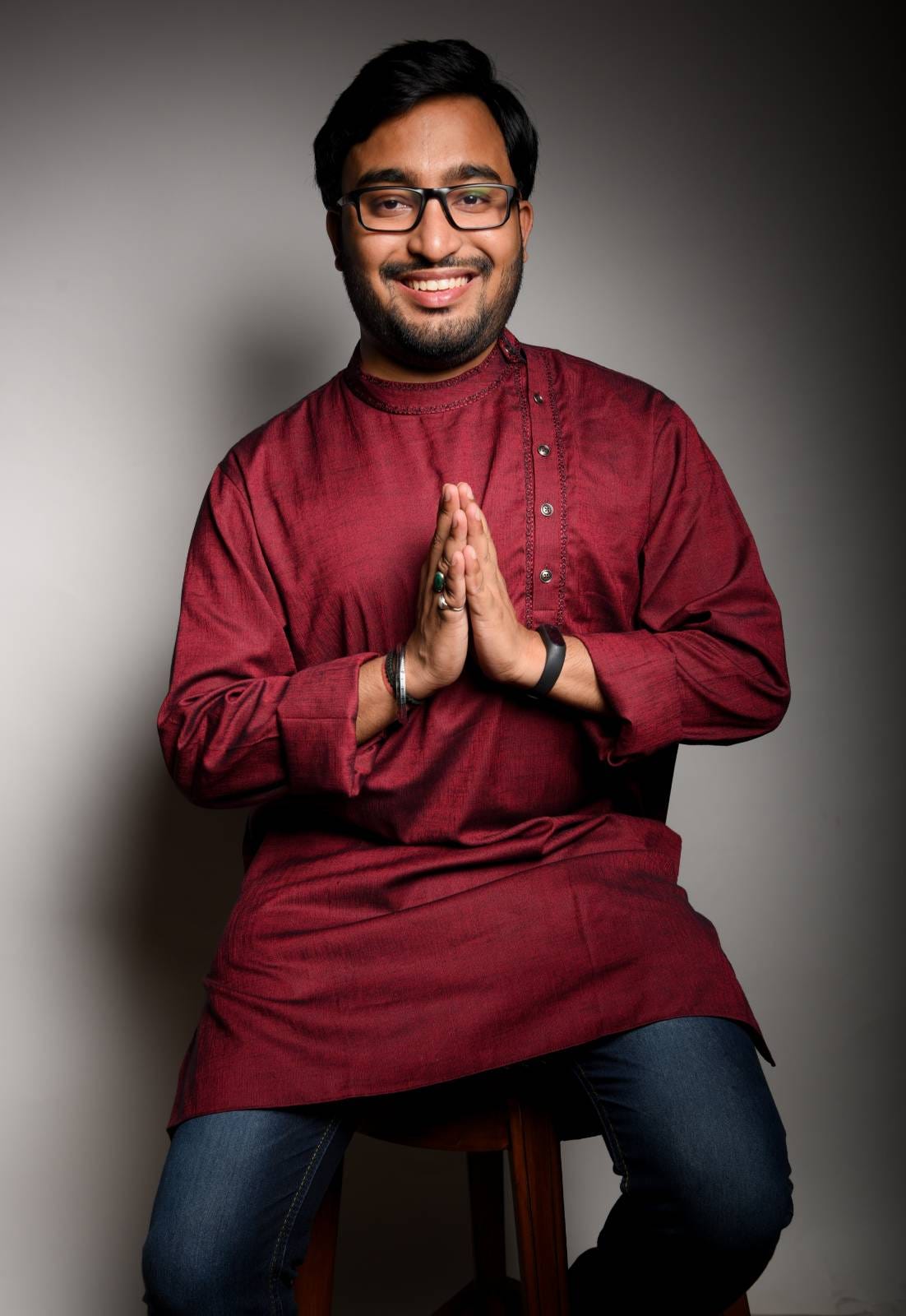 Rudrabha Mukherjee is in namaste pose, wearing a kurta and jeans.