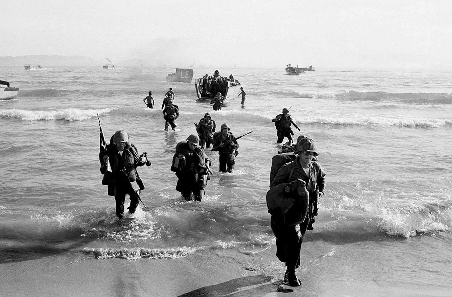 U.S. Marines, laden with heavy equipment, wade ashore at dawn on Red Beach near Da Nang, marking a significant early deployment of American ground combat troops in Vietnam, April 10, 1965. U.S. Marines, laden with heavy equipment, wade ashore at dawn on Red Beach near Da Nang, marking a significant early deployment of American ground combat troops in Vietnam, April 10, 1965.