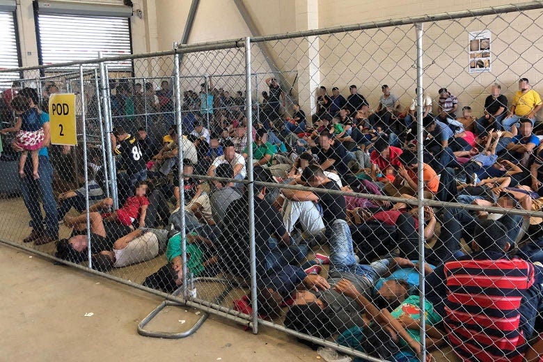 Parents and children sitting on the floor, crowded into a cage inside the detention facility. Parents and children sitting on the floor, crowded into a cage inside the detention facility.