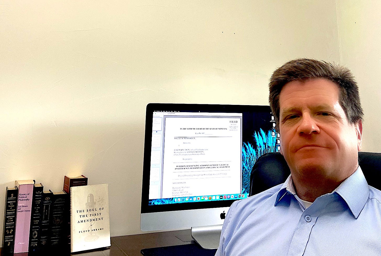 man in blue shirt in front of computer
