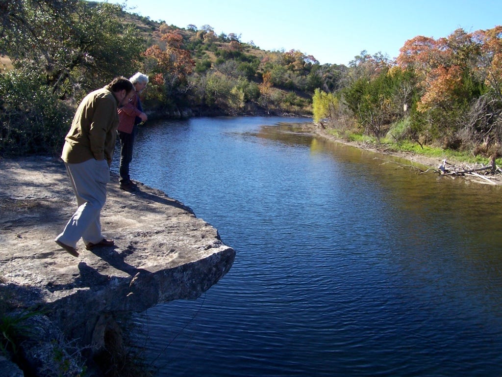 A couple of people walking on a rock ledge

AI-generated content may be incorrect.