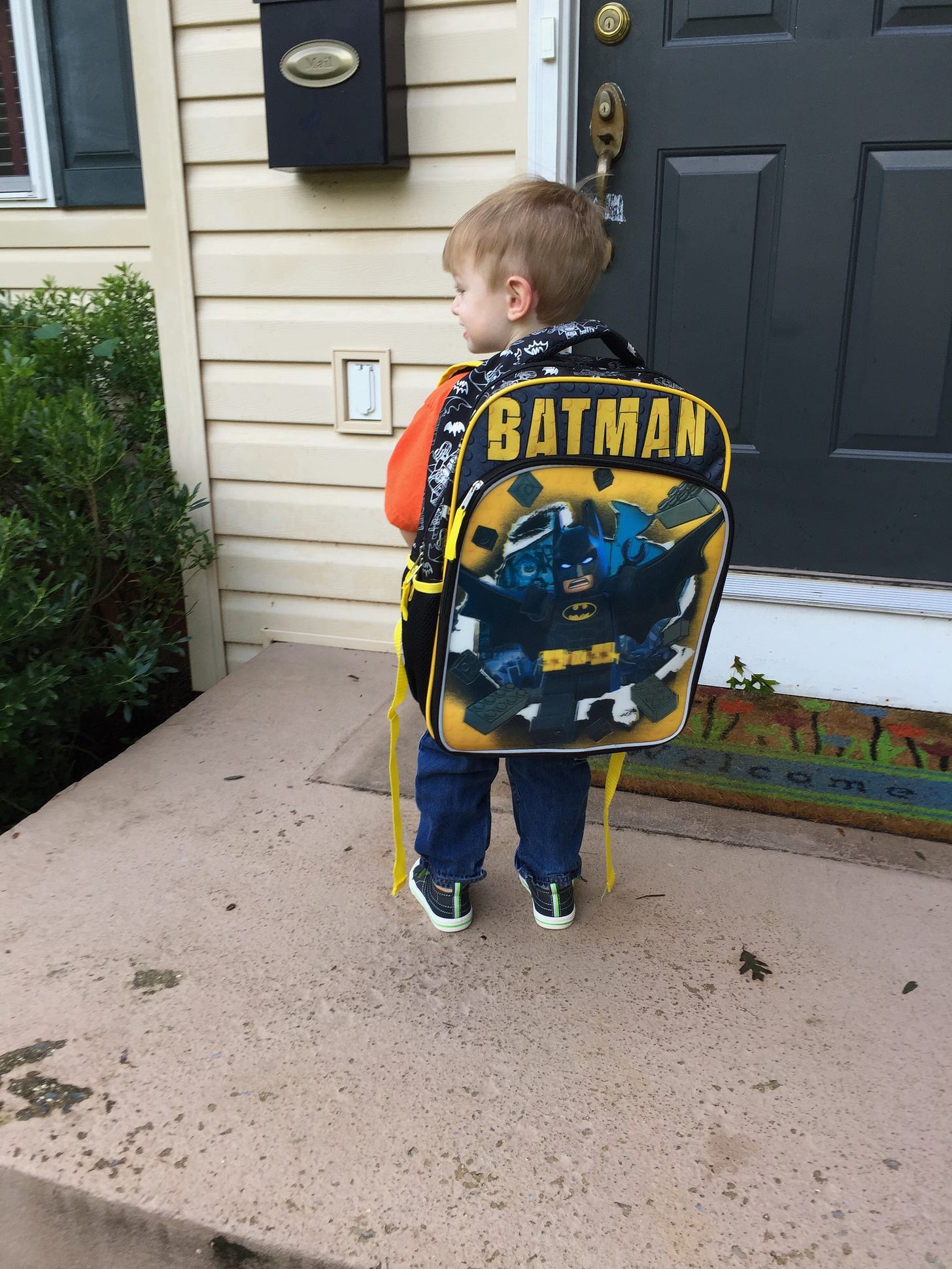 My younger son (a white boy) with a Batman backpack standing on the front porch My younger son (a white boy) with a Batman backpack standing on the front porch