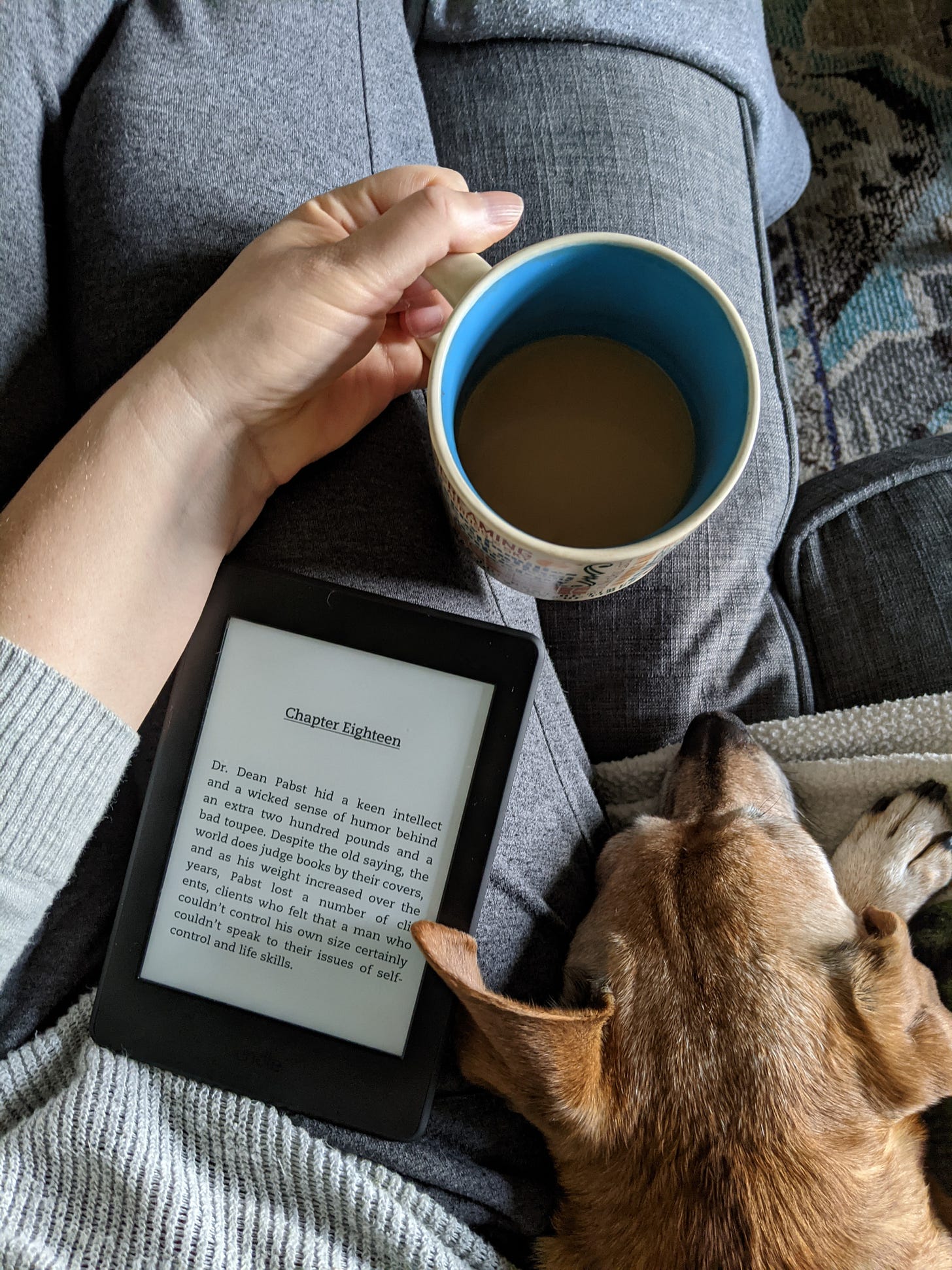 the author cozies up with her dog, a book, and a hot cup of tea