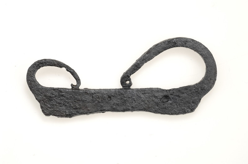 An iron Viking Age fire striker, a flat piece of iron about palm length and curled on each end, which was used to create sparks.