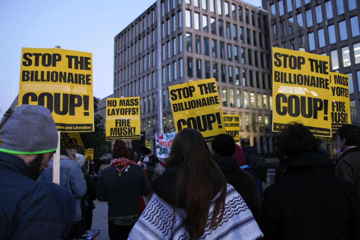 Demonstrators gather outside of the Office of Personnel Management to protest federal layoffs and demand the termination of Elon Musk from the "Department of Government Efficiency" (DOGE) in Washington, D.C., on February 7, 2025. Demonstrators gather outside of the Office of Personnel Management to protest federal layoffs and demand the termination of Elon Musk from the "Department of Government Efficiency" (DOGE) in Washington, D.C., on February 7, 2025.