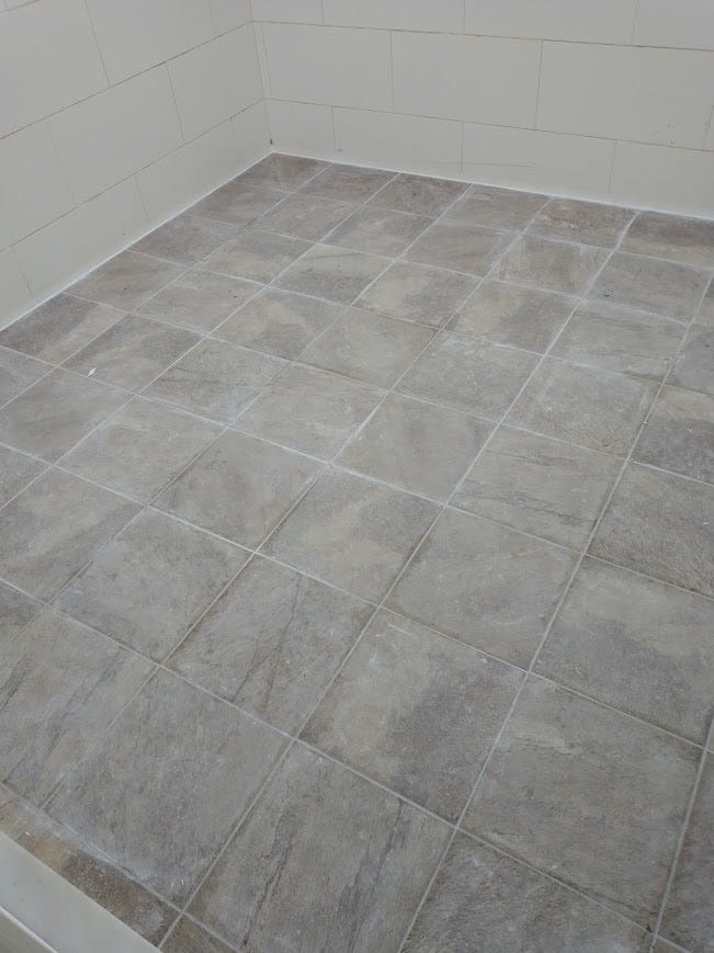 An incredibly bland picture of greyish tile laid out in a courtyard with even more boring white tile walls. I'm sure it will clean up nicely... Meh.
