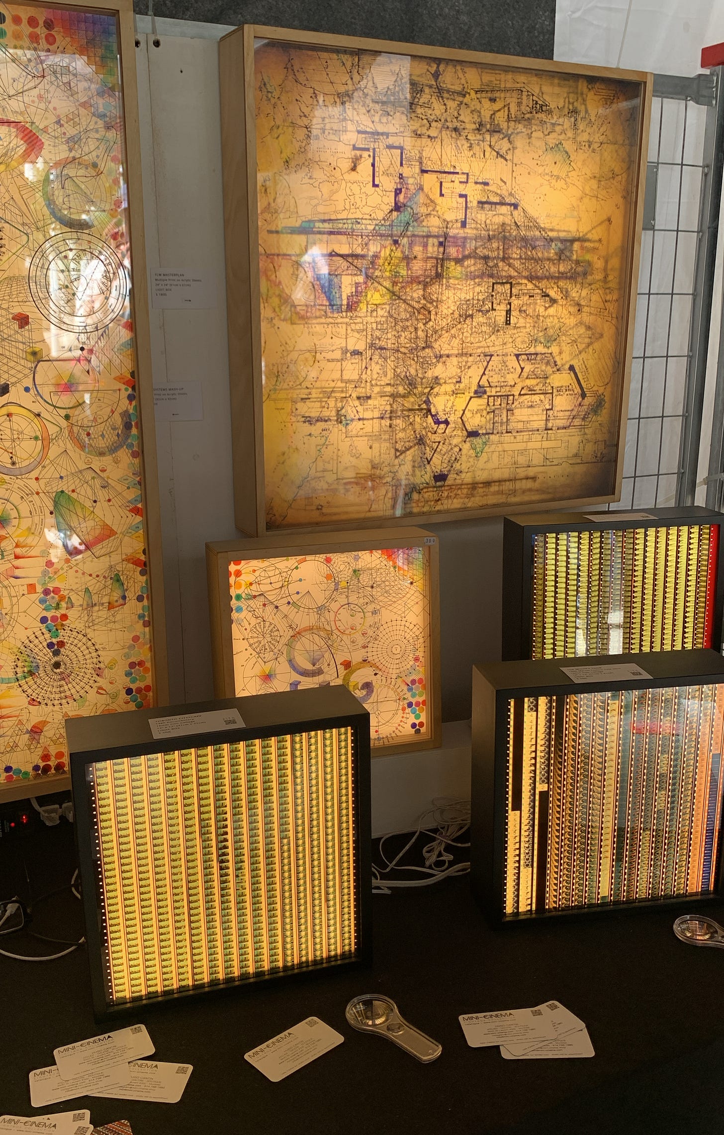 A series of lightboxes with film reels, maps, and other ephemera.