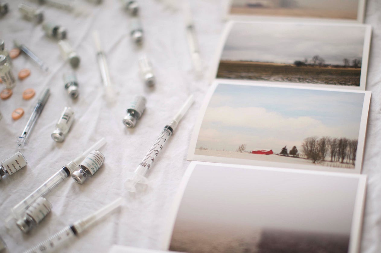 Photographic prints of my documentary project “Fallow” alongside my IVF paraphernalia including infertility treatment drug vials and needles. (Credit: me.) Photographic prints of my documentary project “Fallow” alongside my IVF paraphernalia including infertility treatment drug vials and needles. (Credit: me.)